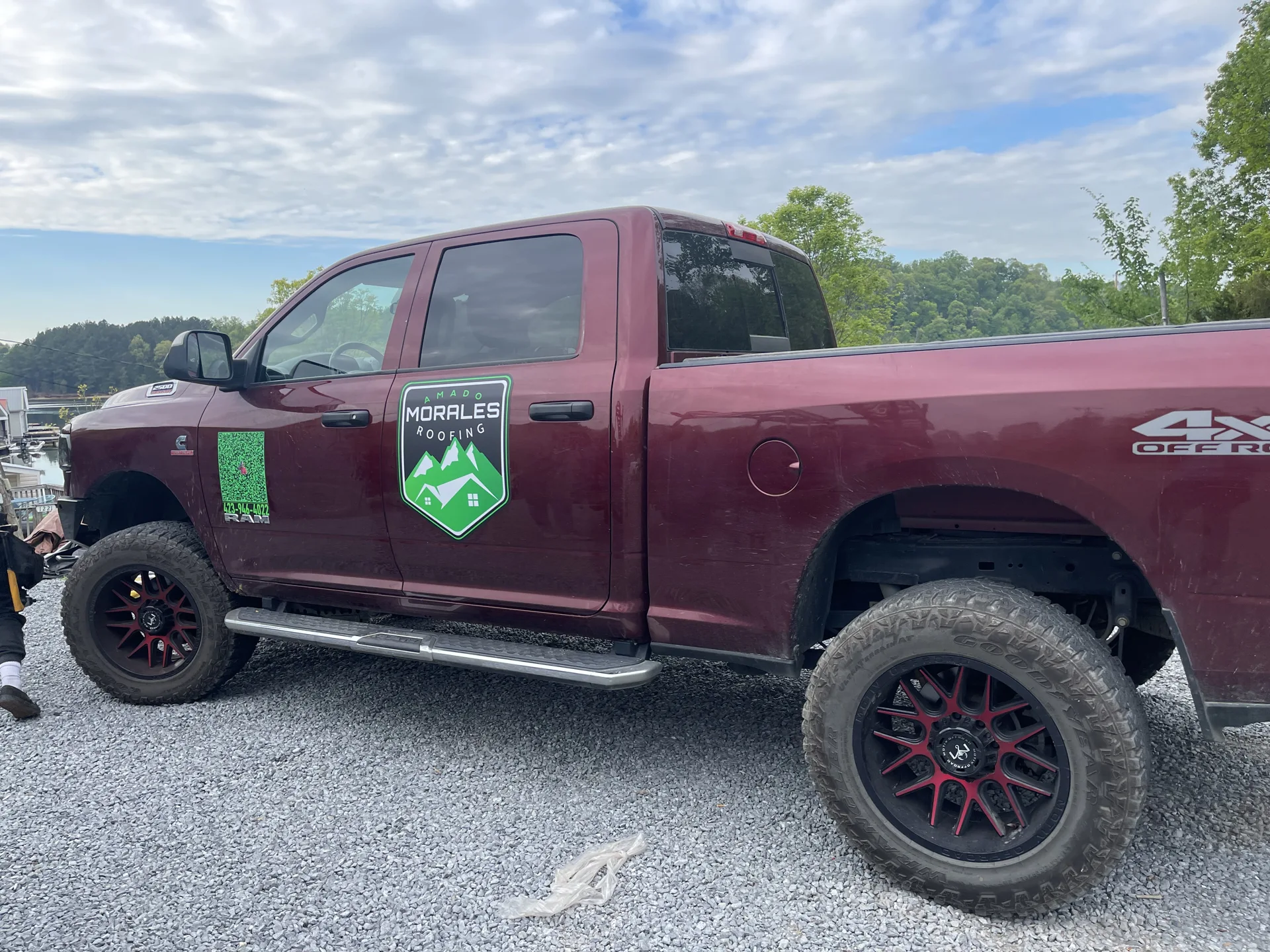 Red company pickup truck displaying the Amado Morales Roofing logo