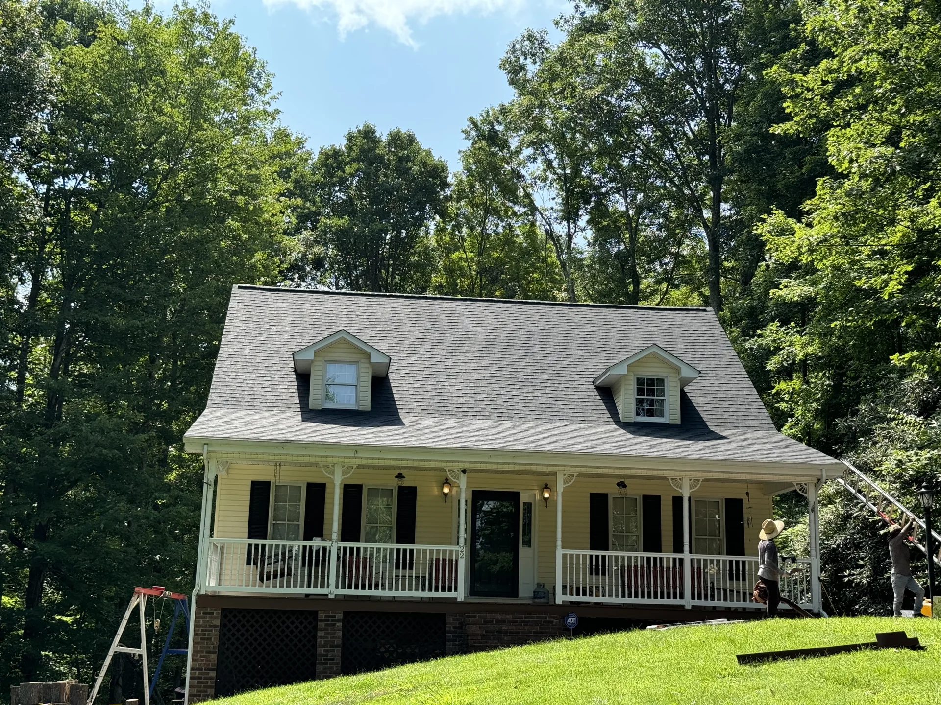 Light-colored home with a front porch and dark dormer roof